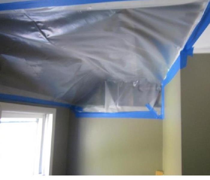 ceiling drywall removed and covered with plastic sheeting