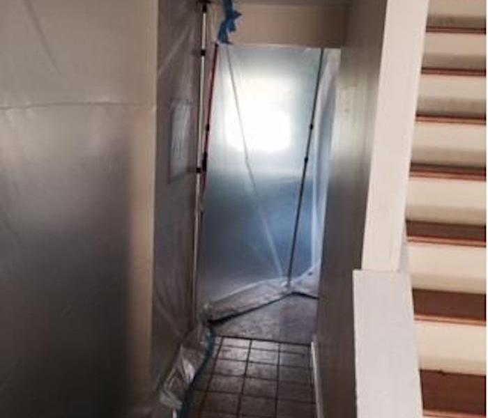 hallway and stairwell in home with plastic sheet hung